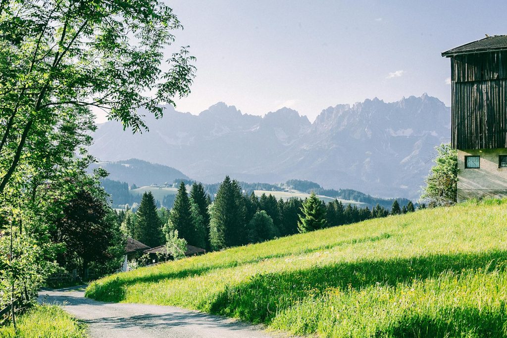 Idyllic cottage in the countryside with lush greenery and mountain scenery.