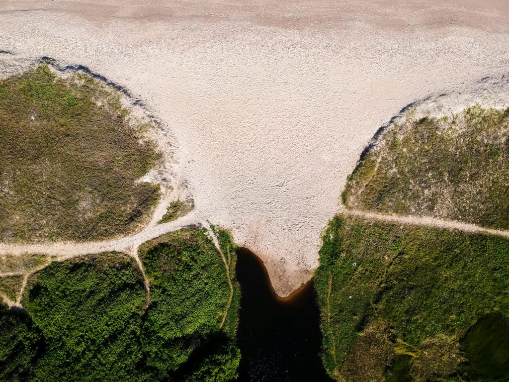 A stunning aerial shot capturing a scenic landscape with sandy shores and lush greenery in Taperoá, Brazil.