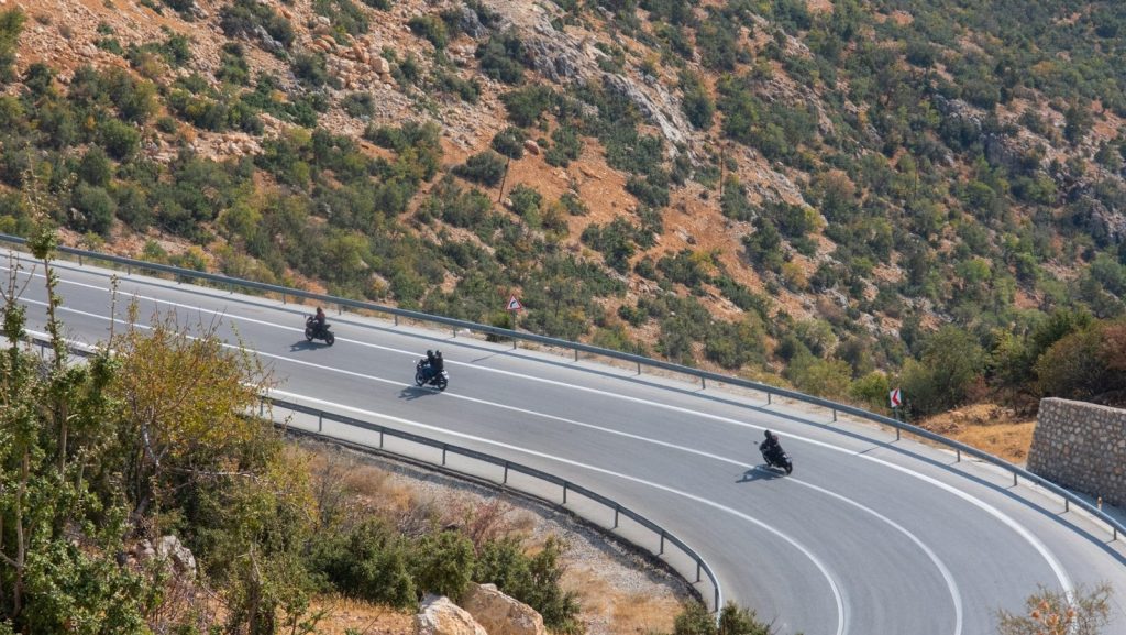 a group of people riding motorcycles down a curvy road