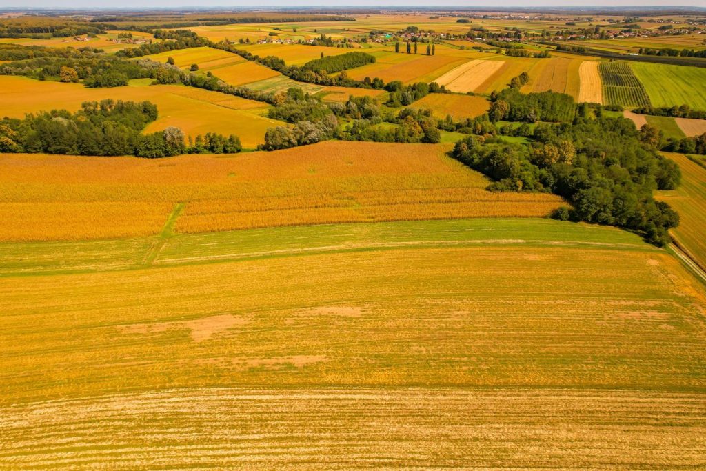 Drone shot of expansive farmland and fields in Garešnica, Croatia during fall, showcasing agricultural beauty.