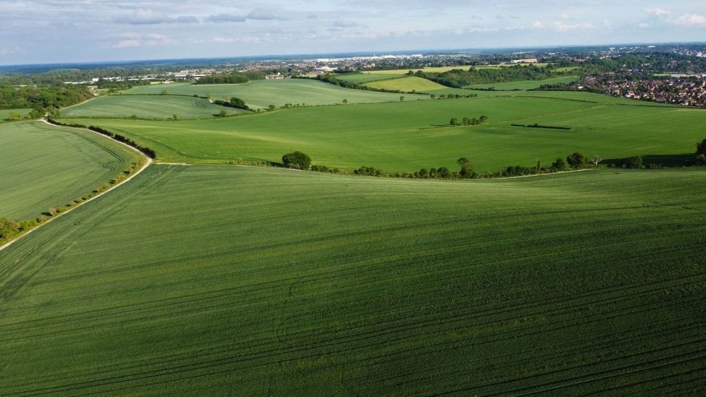 Aerial drone view of lush green fields in Central Bedfordshire, England, showcasing beautiful landscapes and rural scenery.