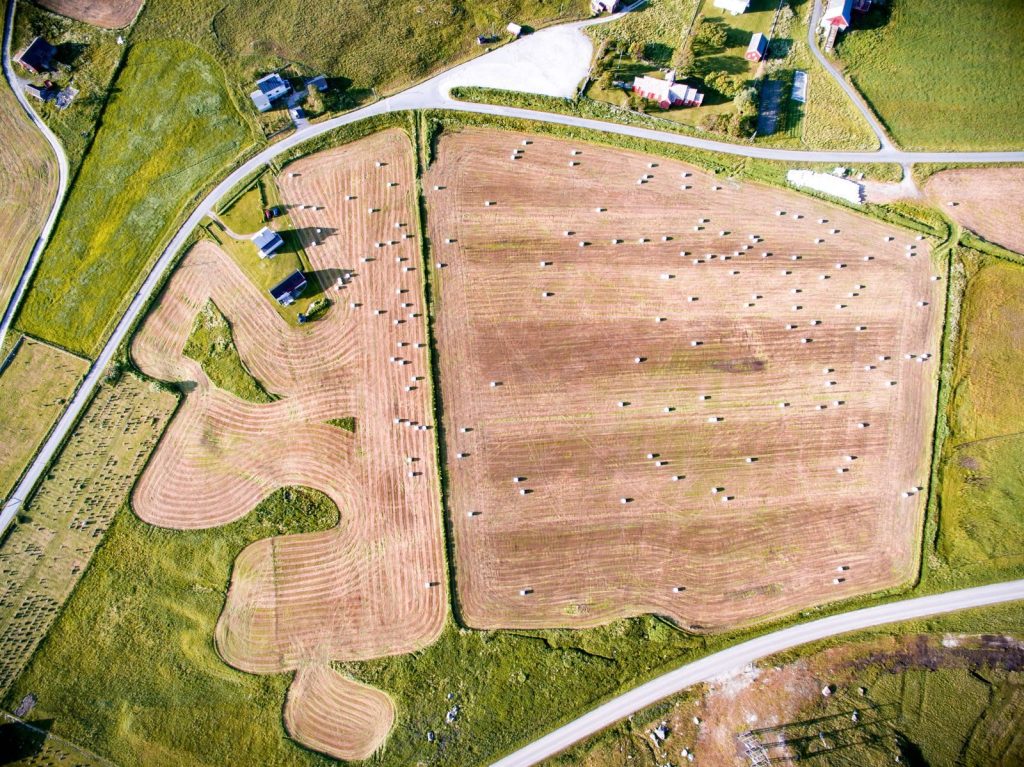 Drone shot of hay bales on a countryside agricultural field