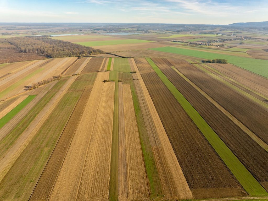 Stunning aerial view of expansive farmland near Garešnica, Croatia, showcasing varied crop patterns.