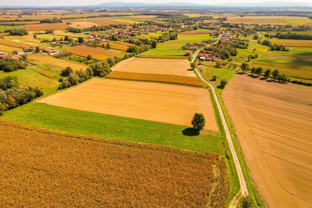 High-altitude aerial view of vibrant rural fields and villages in Garešnica, Croatia's countryside.